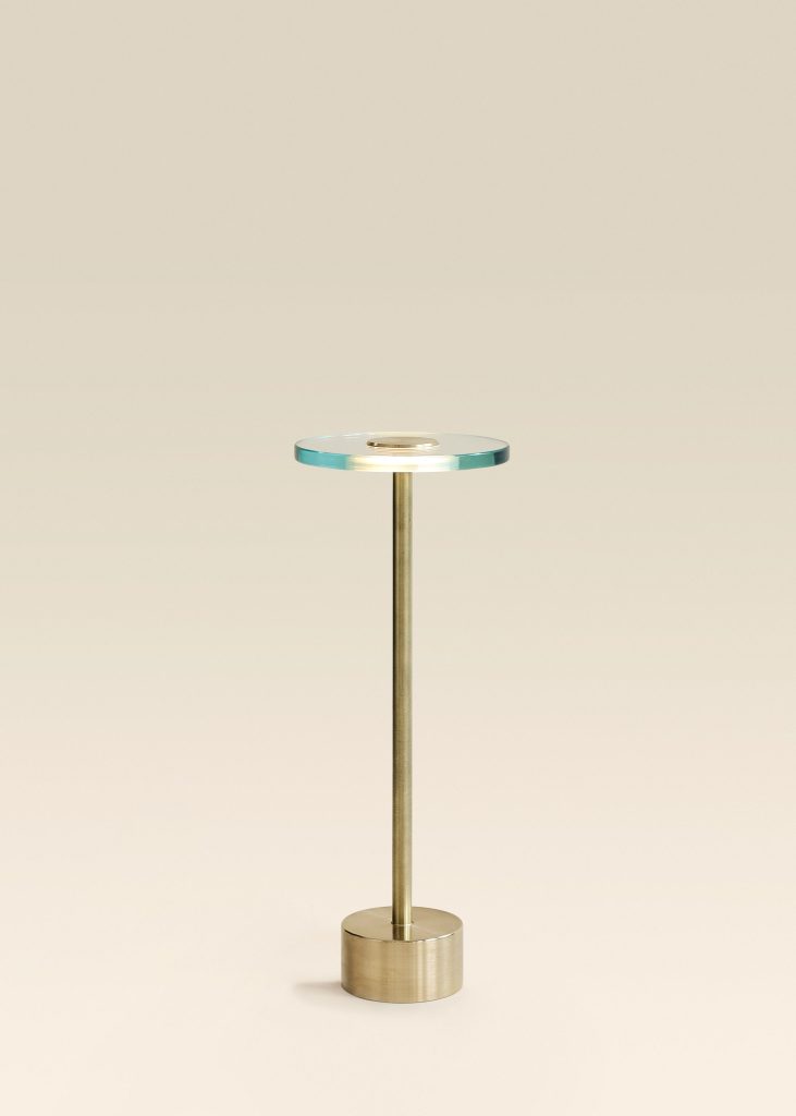 Circular glass table la,p: Tall, brass-based lights create an inviting atmosphere, a Nicolo Taliani creation.